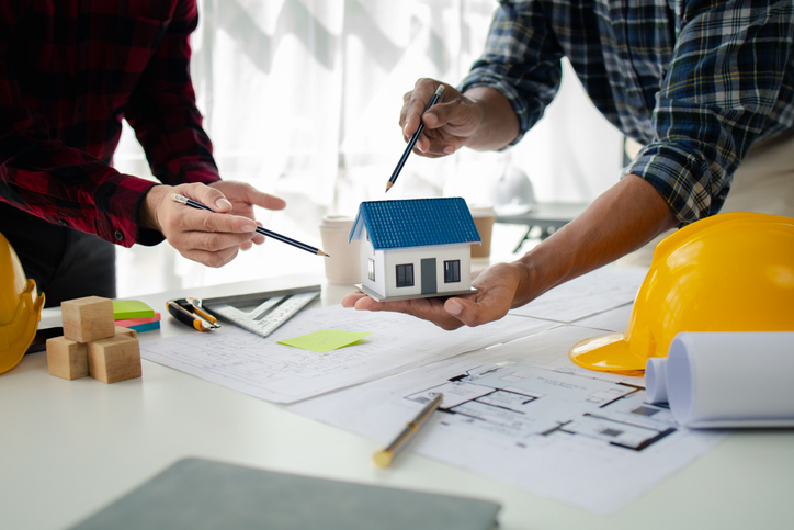 The home design architects are reviewing the house plan draft, the project commissioned by the client, and the custom design before delivery. Interior design and decoration ideas.